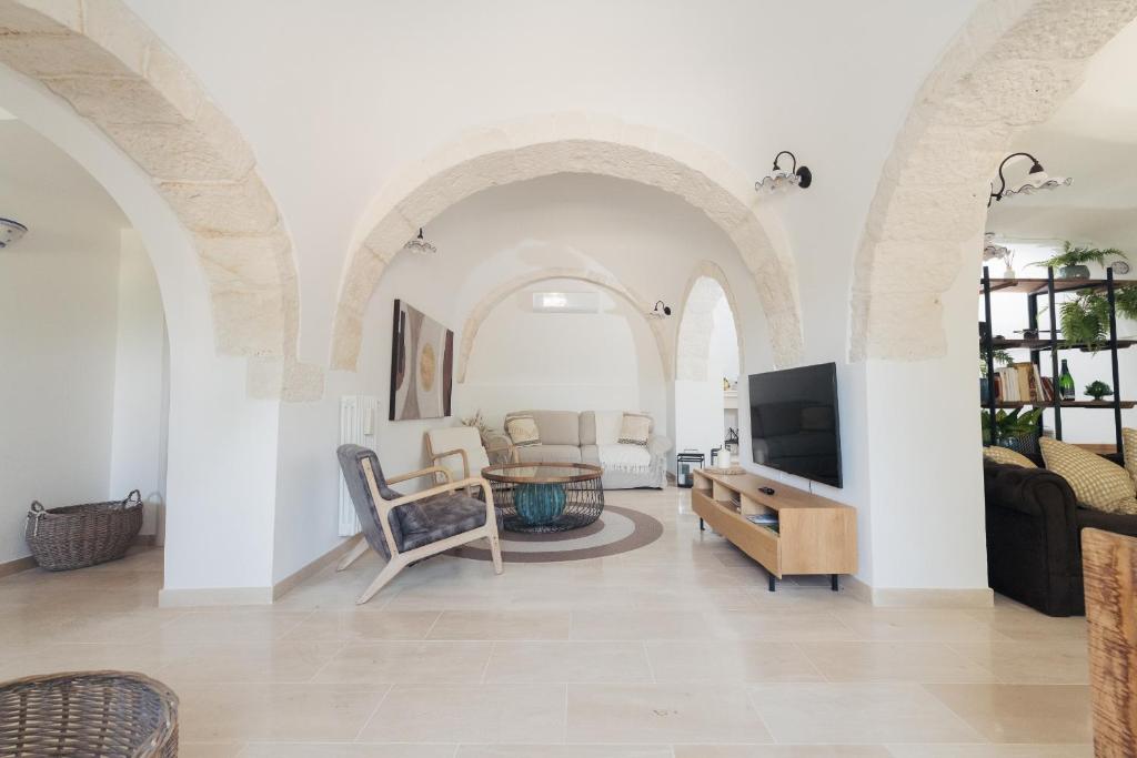 - un salon avec des murs et des arches blancs dans l'établissement Trulli Greta, luxury villa with wonderful pool, à Martina Franca