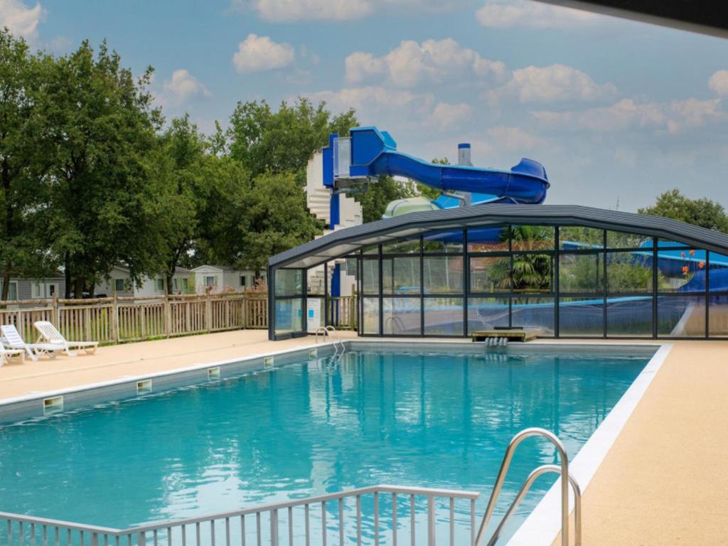 une grande piscine avec un toboggan aquatique dans l'établissement Mobil home SGB, à La Boissière-de-Montaigu