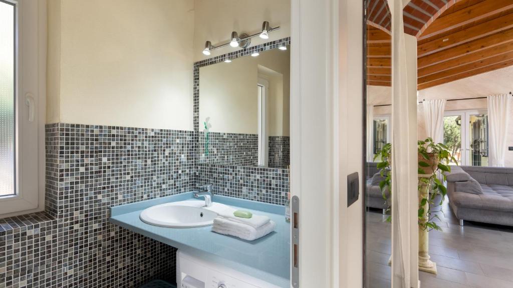 une salle de bain avec un lavabo et un miroir dans l'établissement VILLA VITTORIO 6&2 Emma Villas, à Imperia