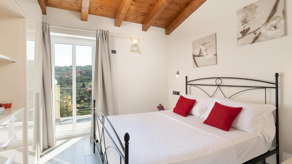 une chambre avec un grand lit avec des oreillers rouges dans l'établissement VILLA VITTORIO 6&2 Emma Villas, à Imperia 19 autres photos
