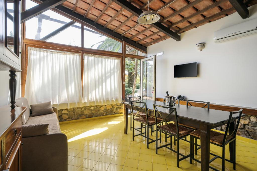 un salon avec une table, des chaises et un canapé dans l'établissement Residence Le Axidie, à Vico Equense