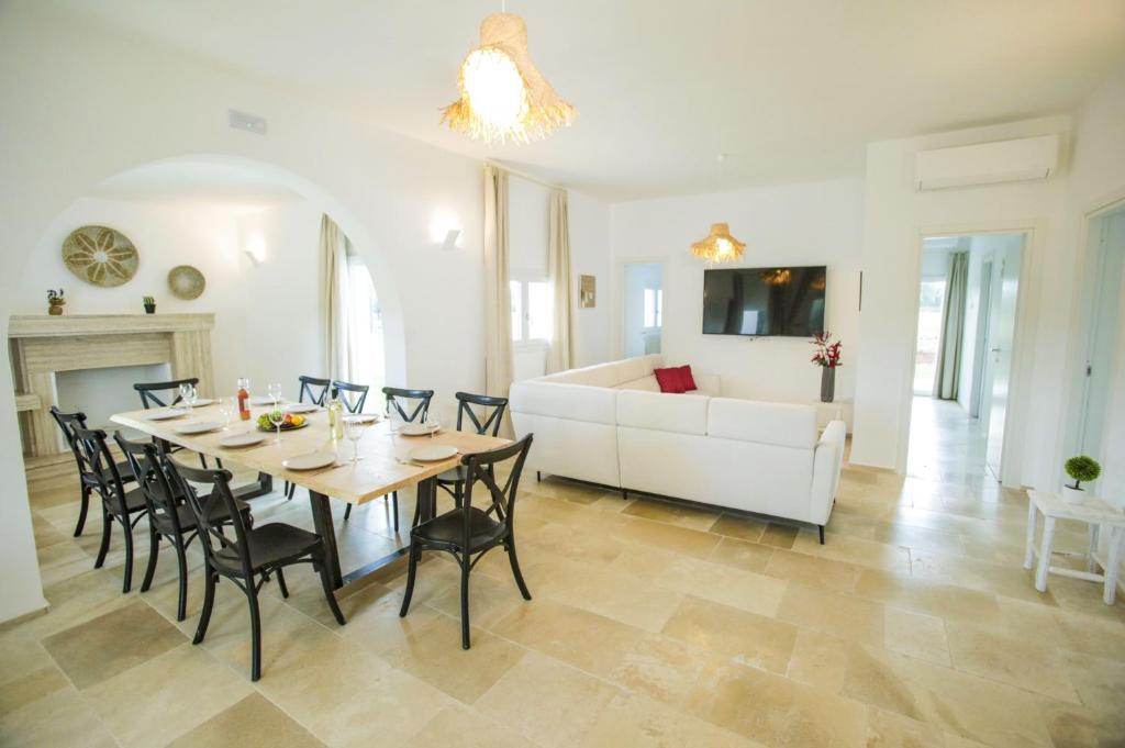 une salle à manger et un salon avec une table et des chaises dans l'établissement Villa Gabriella by Villa Plus, à Carovigno