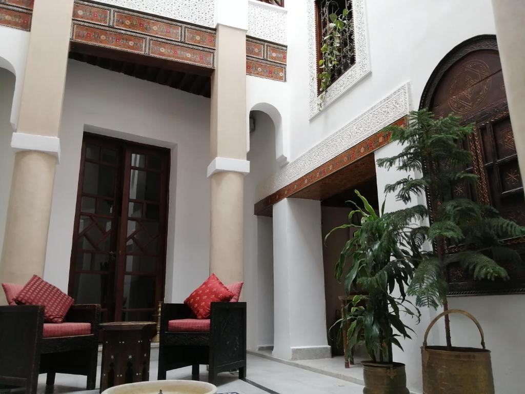 une cour d'une maison avec des chaises et des tables dans l'établissement Dar Eva, à Fès