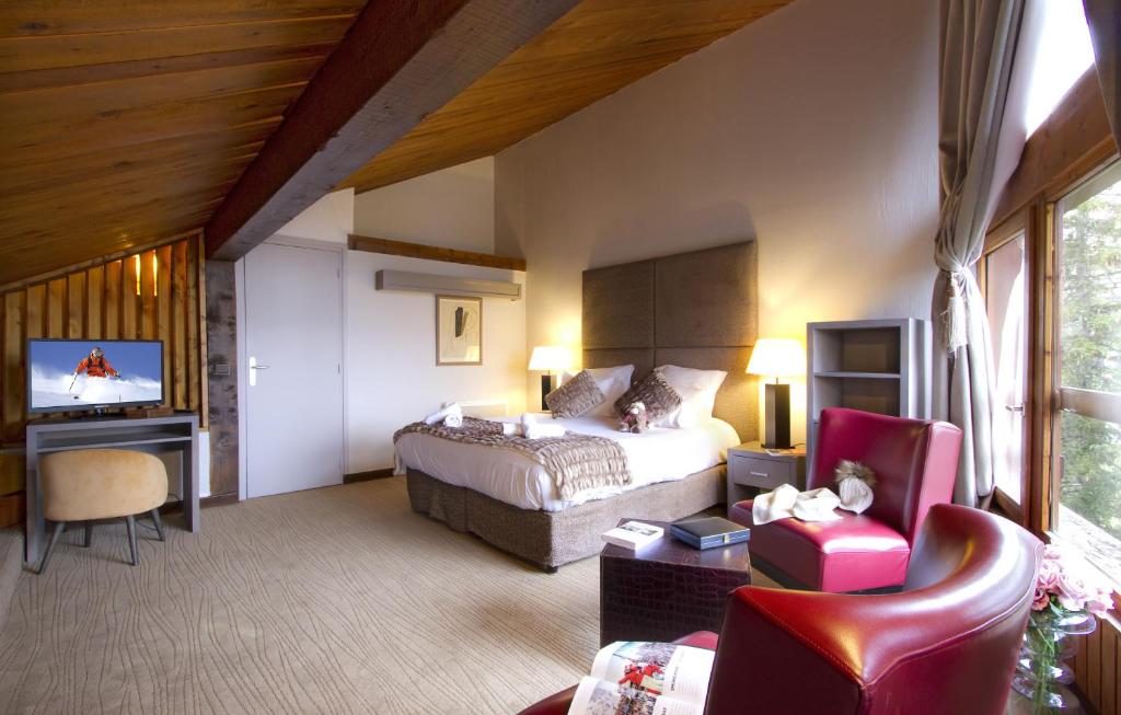une chambre d'hôtel avec un lit et une télévision dans l'établissement Odalys Hotel New Solarium, à Courchevel