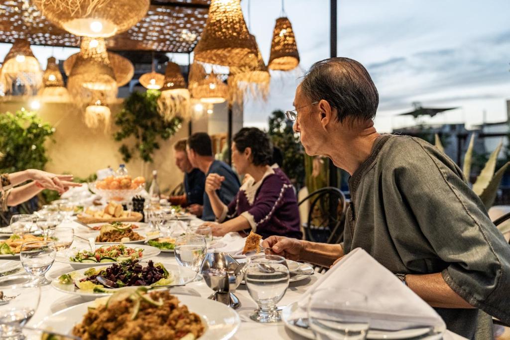 un groupe de personnes assises à une table en train de manger dans l'établissement Riad Dar El Médina - Heated Swimming pool, jacuzzi & Spa, à Marrakech
