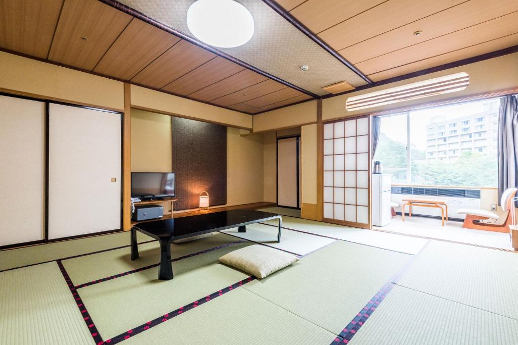 un salon avec une table et une télévision dans l'établissement Ooedo Onsen Monogatari Masuya, à Osaki