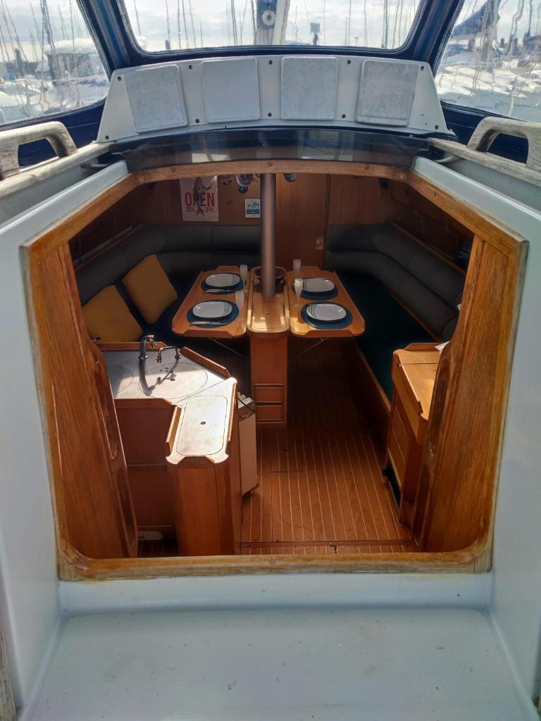 - une vue sur l'intérieur d'un bateau avec des tables dans l'établissement Location Unique : Le Bateau d'Antoine à Roscoff, à Roscoff