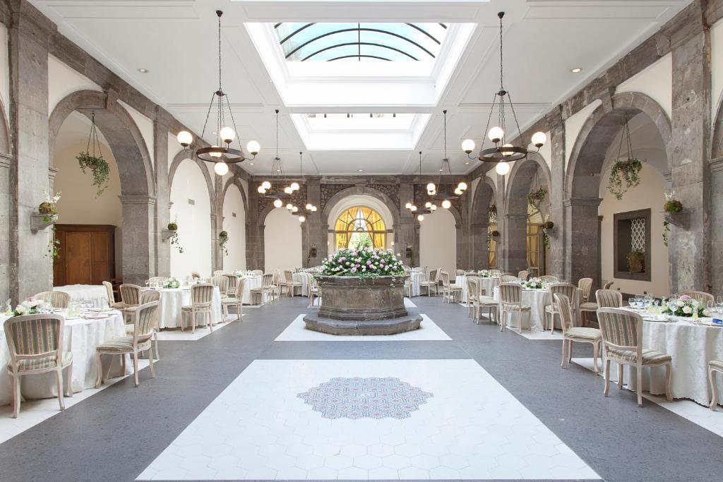 une salle de banquet avec des tables et des chaises blanches ainsi qu'une fontaine dans l'établissement Grand Hotel Cocumella, à Sant'Agnello 277 autres photos