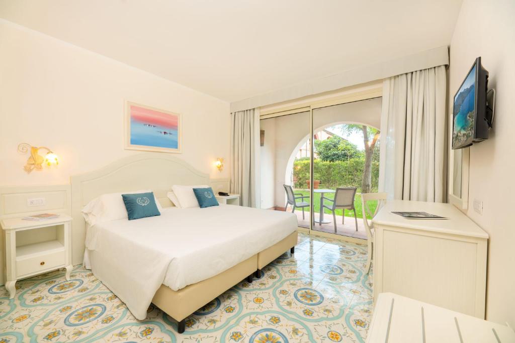 une chambre d'hôtel avec un lit et un balcon dans l'établissement Hotel Del Golfo, à Procchio