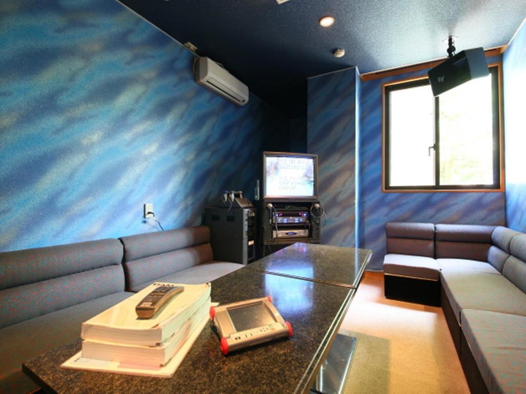 un salon avec un canapé et une table en verre dans l'établissement Hotel Yume-no-yu, à Omachi