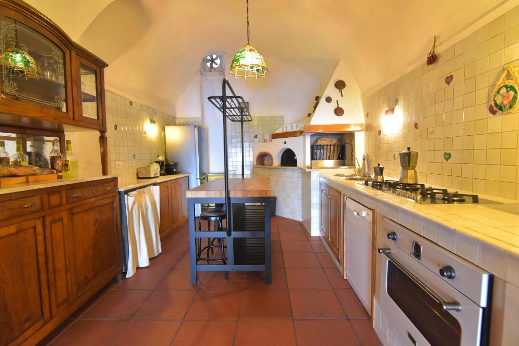 une grande cuisine avec des armoires en bois et une cuisinière four supérieur dans l'établissement Villa Eustachio, à Scala