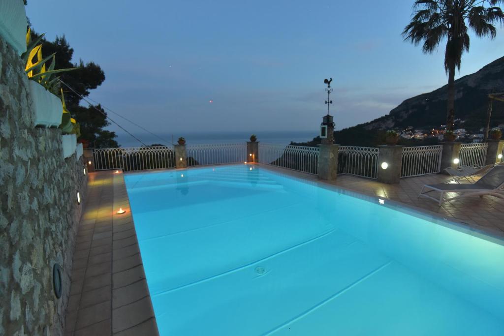 - une grande piscine avec des lumières bleues dans un bâtiment dans l'établissement Villa Eustachio, à Scala