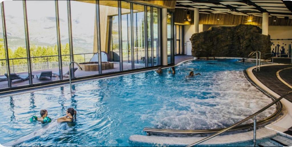 un groupe de personnes nageant dans une piscine dans l'établissement Appartement superdevoluy, à Saint-Étienne-en-Dévoluy