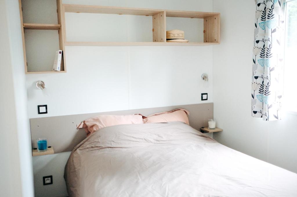 Cette petite chambre comprend un lit avec des draps blancs. dans l'établissement Mobil Home XXL 4 chambres - Camping Les Relarguiers, à Beauvezer