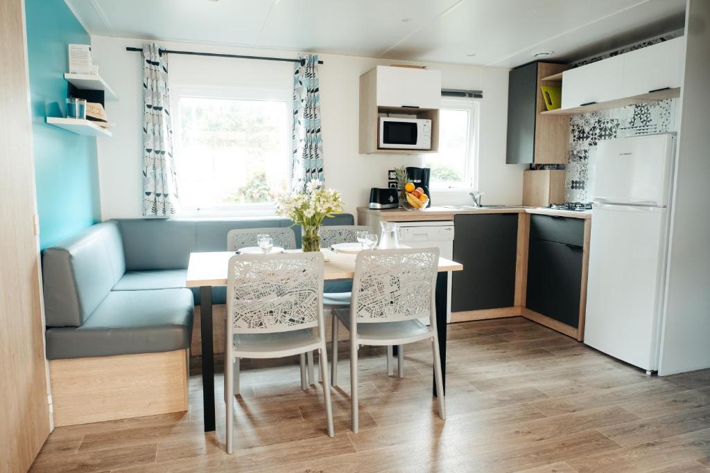 une cuisine et une salle à manger avec une table et des chaises dans l'établissement Mobil Home XXL 4 chambres - Camping Les Relarguiers, à Beauvezer 9 autres photos