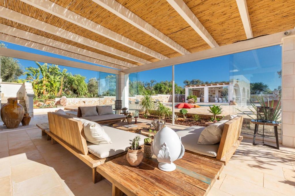 un patio extérieur avec une table et des chaises en bois dans l'établissement Ca` della Roccia by Perle di Puglia, à Ostuni