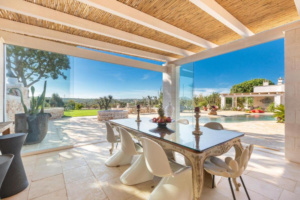 une salle à manger extérieure avec une table et des chaises dans l'établissement Ca` della Roccia by Perle di Puglia, à Ostuni