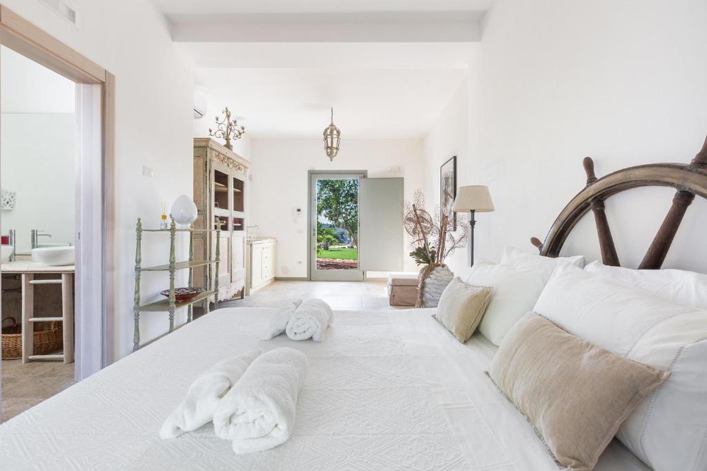 - une chambre blanche avec des serviettes sur un lit dans l'établissement Ca` della Roccia by Perle di Puglia, à Ostuni 45 autres photos