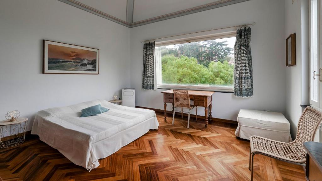 une chambre avec un lit, une table et une fenêtre dans l'établissement VILLA LIBERTY ALBISOLA 6&2, Emma Villas, à Albisola Superiore