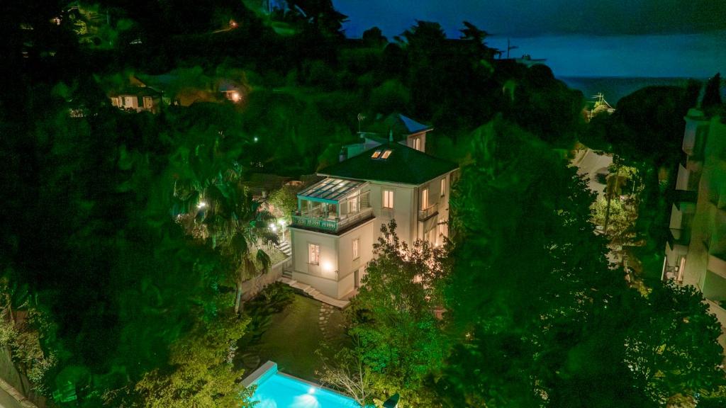 - une vue aérienne sur une maison sur une colline la nuit dans l'établissement VILLA LIBERTY ALBISOLA 6&2, Emma Villas, à Albisola Superiore