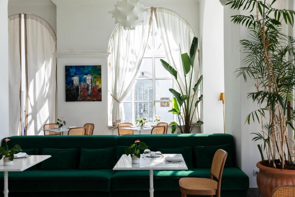 - un canapé vert dans une salle à manger avec des tables dans l'établissement Grand Hotel Cocumella, à Sant'Agnello
