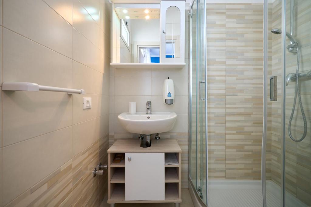 une salle de bain avec un lavabo et une douche en verre dans l'établissement Hotel Villa Del Mar, à Bibione