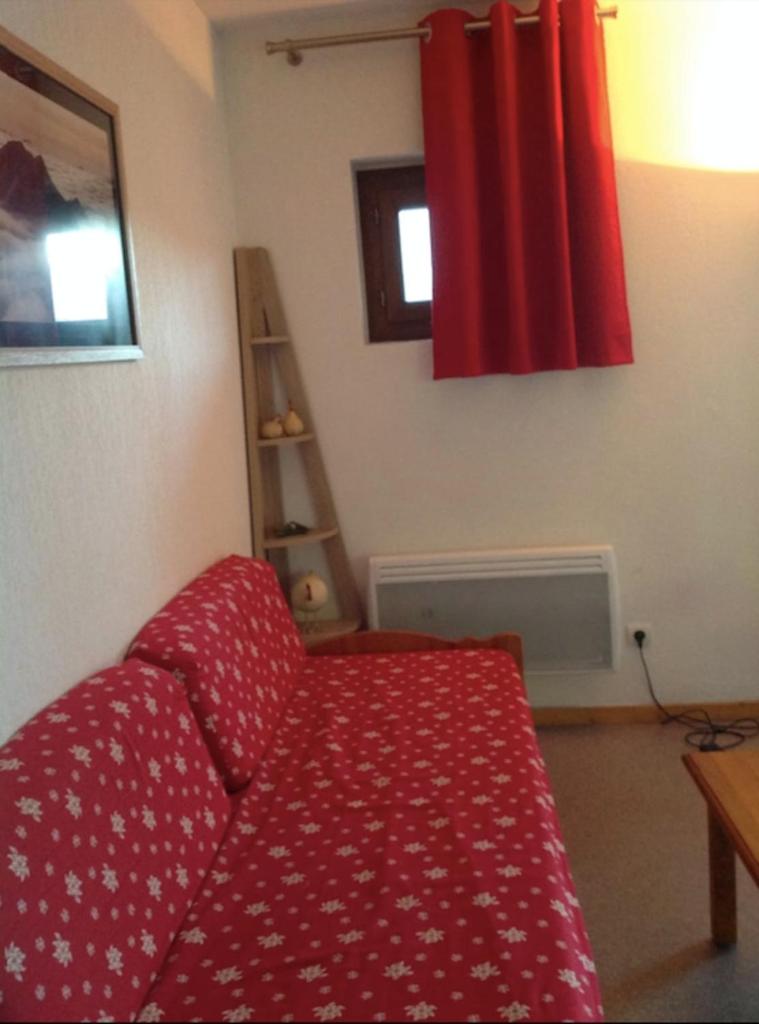 - un salon avec un canapé rouge et un rideau rouge dans l'établissement Equipped apartment in Superdévoluy, à Saint-Étienne-en-Dévoluy