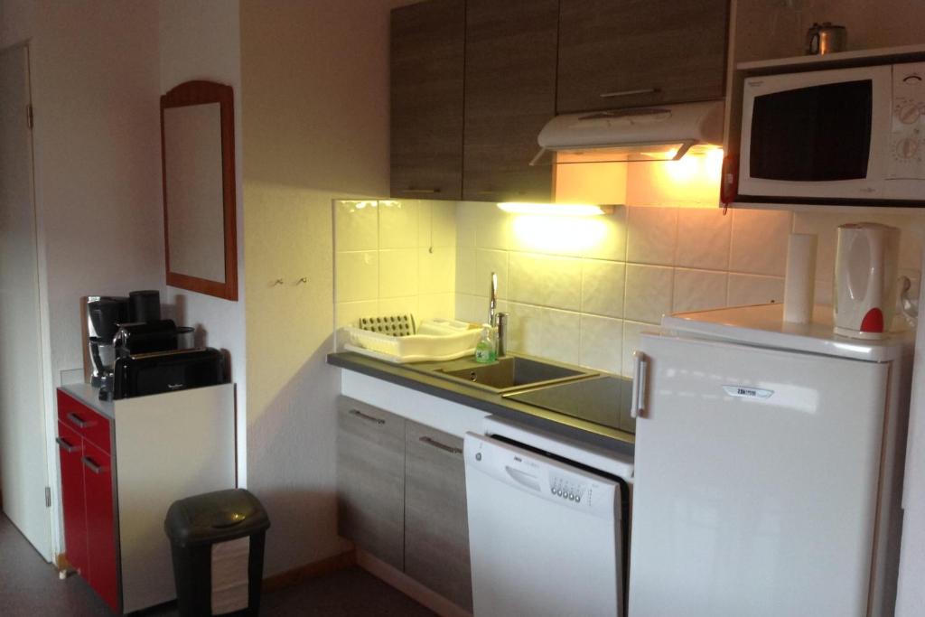une petite cuisine avec un évier et un réfrigérateur dans l'établissement Equipped apartment in Superdévoluy, à Saint-Étienne-en-Dévoluy