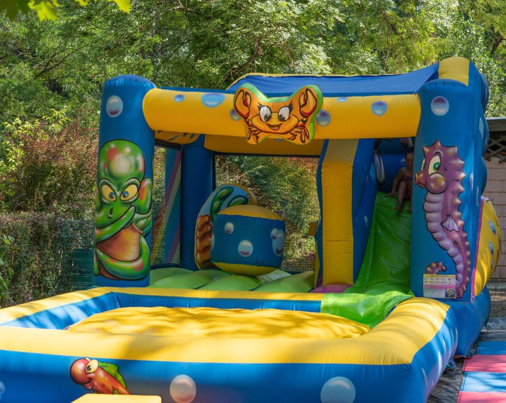 un jeu gonflable avec un équipement de jeux pour enfants dans l'établissement Camping de la Bageasse, à Brioude