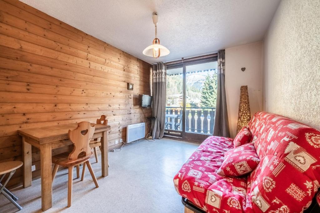 - un salon avec un canapé et un mur en bois dans l'établissement Studio Chatel - Au pieds du Linga, à Châtel