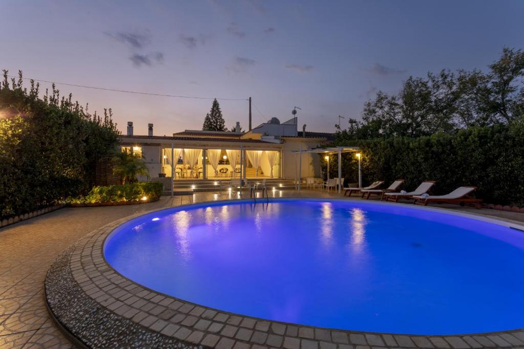 une grande piscine bleue dans une cour dans l'établissement Villa Alexandra - IsulaTravel, à Ispica