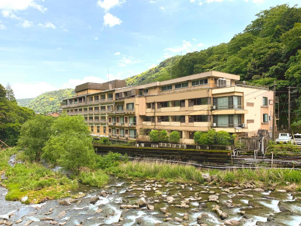 un bâtiment sur le bord d'une rivière dans l'établissement Hakone Pax Yoshino, à Hakone