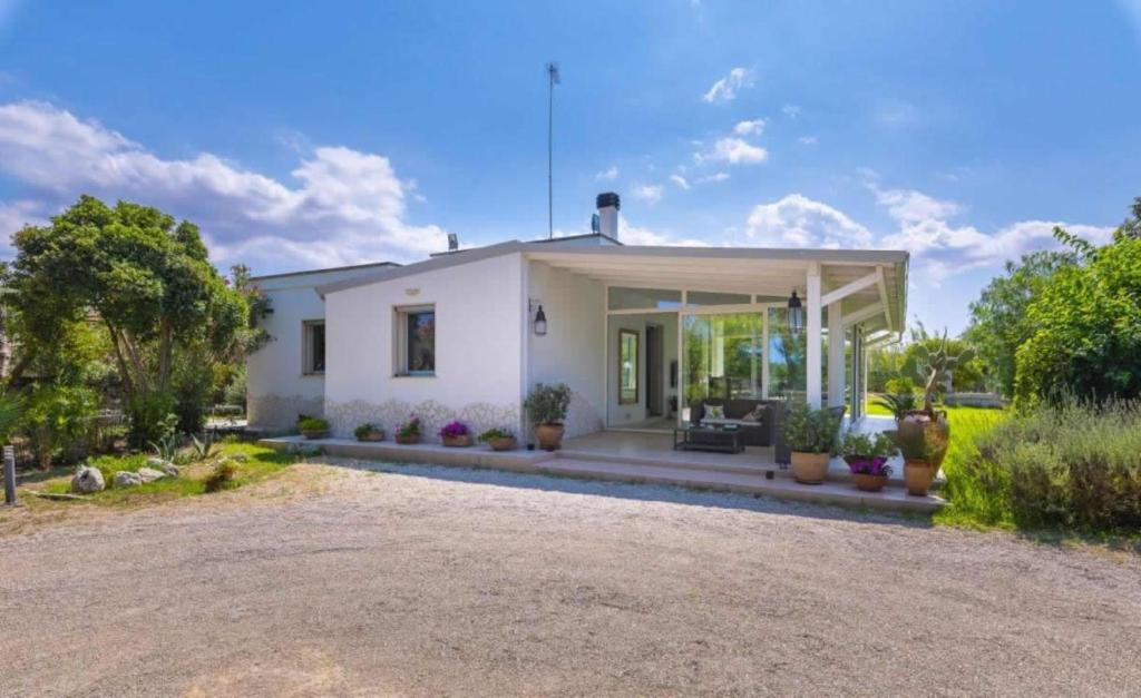 une grande maison blanche avec une allée dans l'établissement La Dimora dei Gelsi, à Castri di Lecce