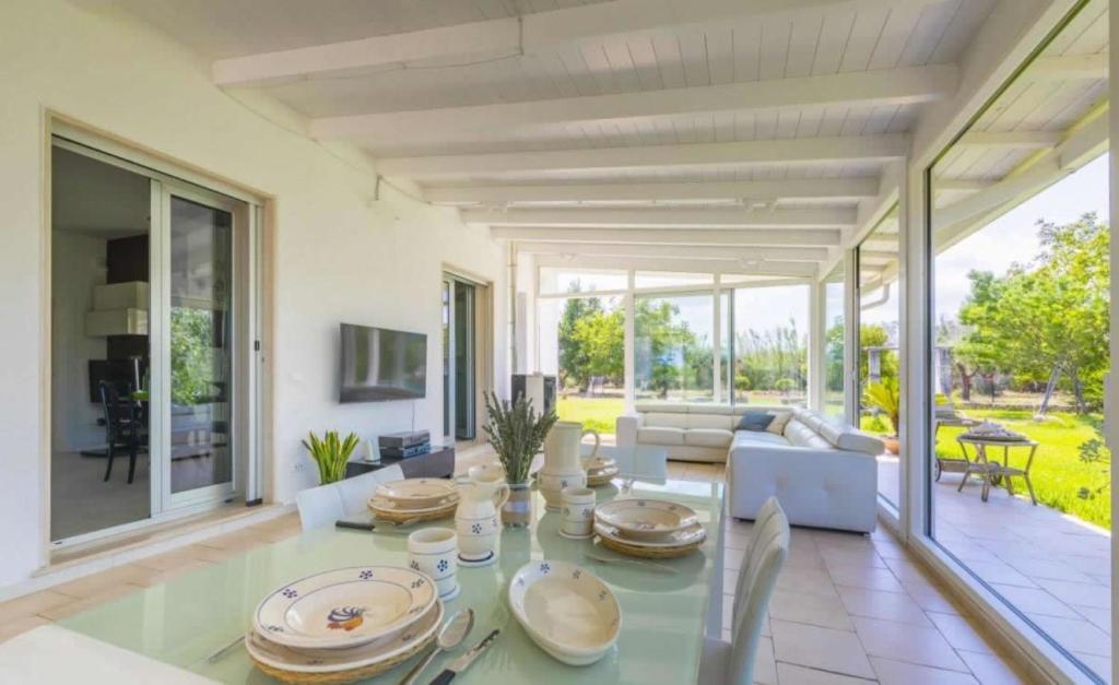 un salon avec une table en verre et des chaises dans l'établissement La Dimora dei Gelsi, à Castri di Lecce