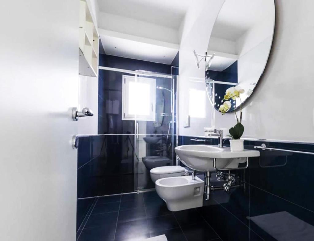 une salle de bain avec un lavabo, des toilettes et un miroir dans l'établissement La Dimora dei Gelsi, à Castri di Lecce