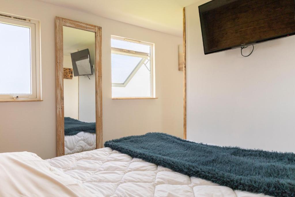 une chambre avec un lit et un miroir dans l'établissement Mobil Home à la Ferme, à Fiennes