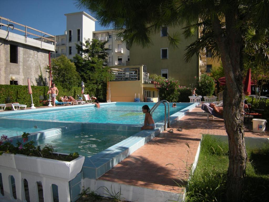 - une piscine avec des personnes assises dans l'eau dans l'établissement Hotel Continental, à Lido di Jesolo