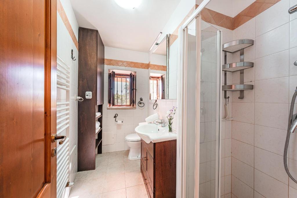 une salle de bain avec un lavabo, des toilettes et une douche dans l'établissement HelloApulia Trulli Serena, à Alberobello