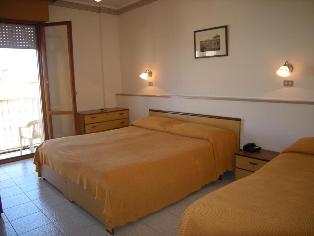 une chambre d'hôtel avec deux lits et une fenêtre dans l'établissement Hotel Continental, à Lido di Jesolo
