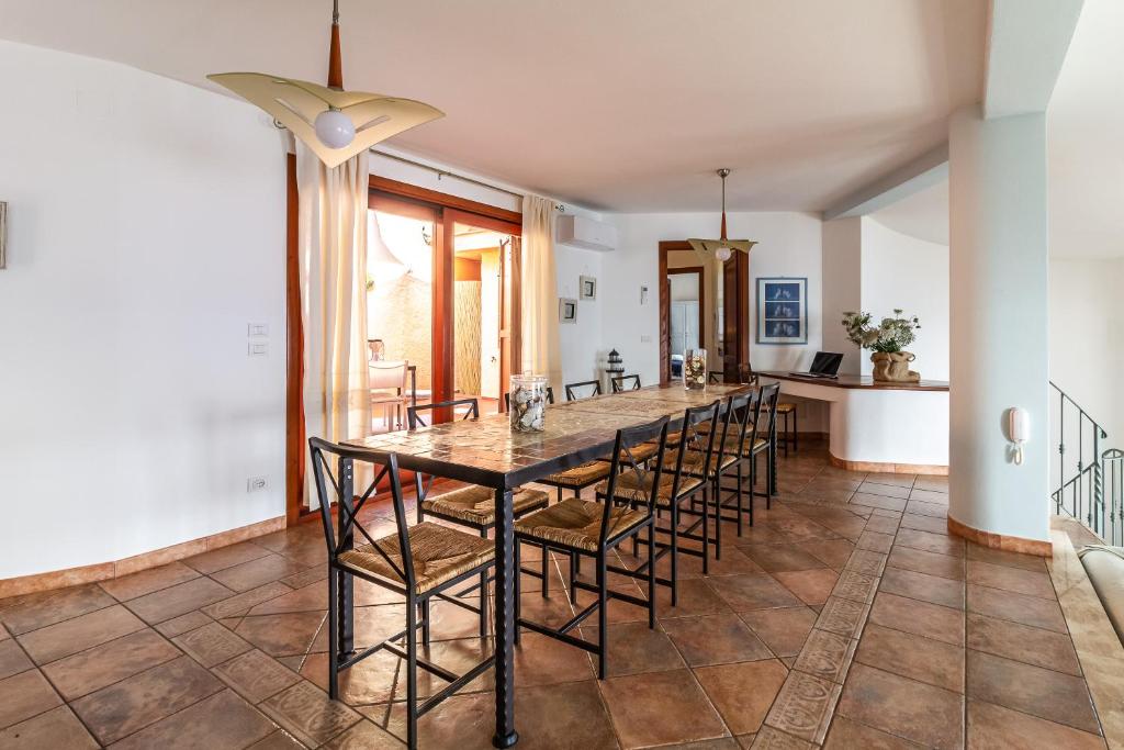 une salle à manger avec une longue table et des chaises dans l'établissement Villa Gemma Torre delle Stelle Coast with infinity pool panoramic terraces and garden, à Torre delle Stelle