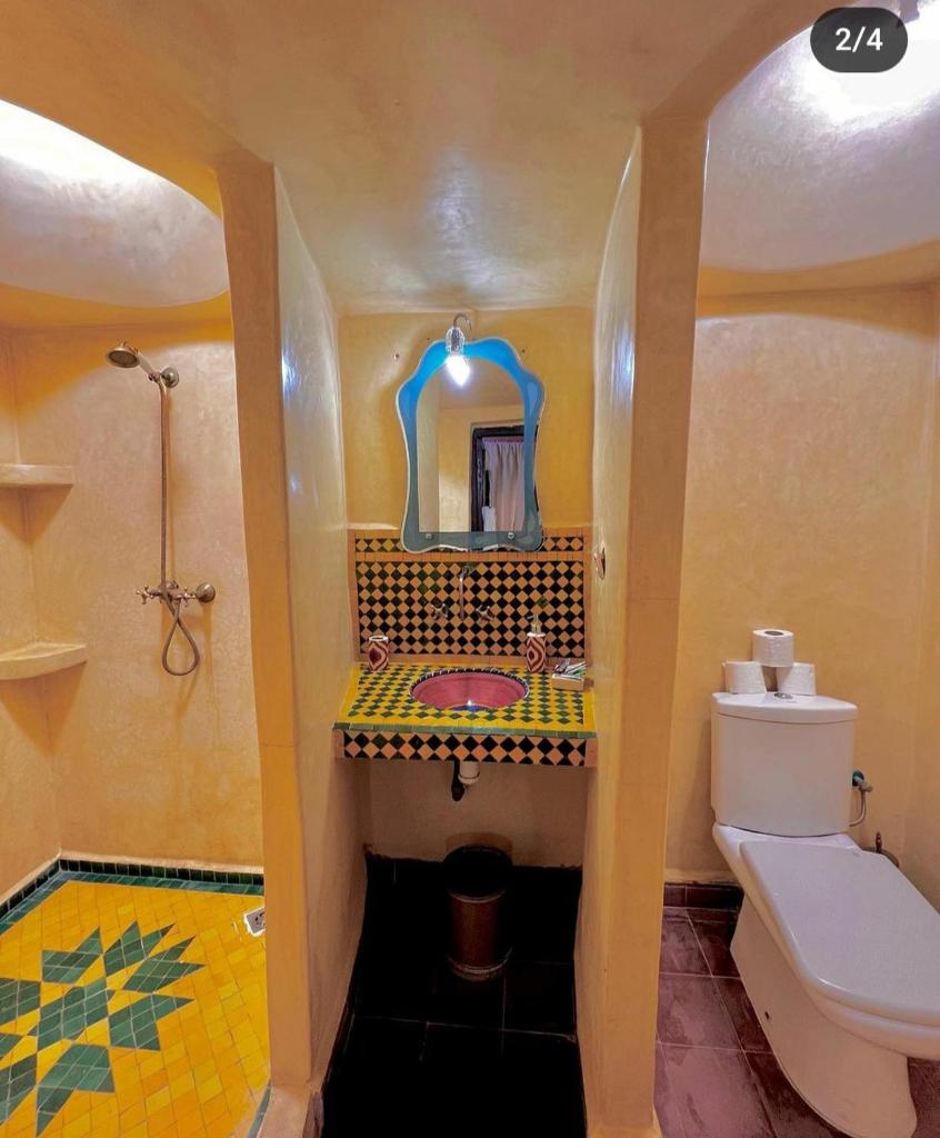 une salle de bain avec toilettes, lavabo et miroir dans l'établissement Riad Chakir Mogador, à Essaouira