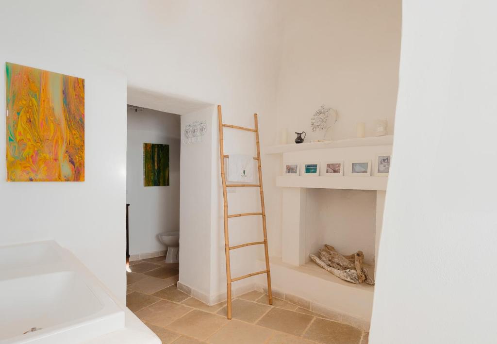 Cette chambre blanche dispose d'une échelle et d'une salle de bains. dans l'établissement Trulli La Formosa - The Fab Stay, à Ostuni