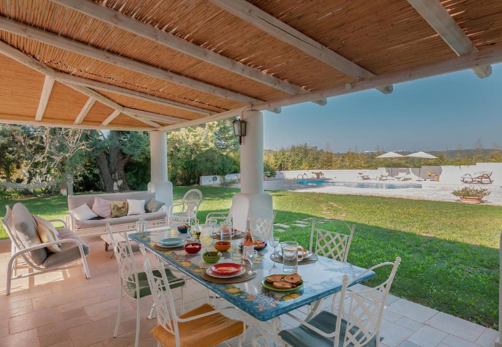 - une table et des chaises sur une terrasse avec piscine dans l'établissement Trulli La Formosa - The Fab Stay, à Ostuni