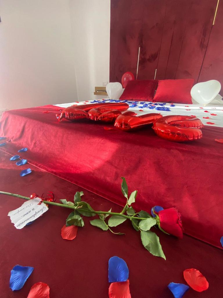 - un lit avec des draps rouges et des fleurs dans l'établissement Luxury Resort, à Licola
