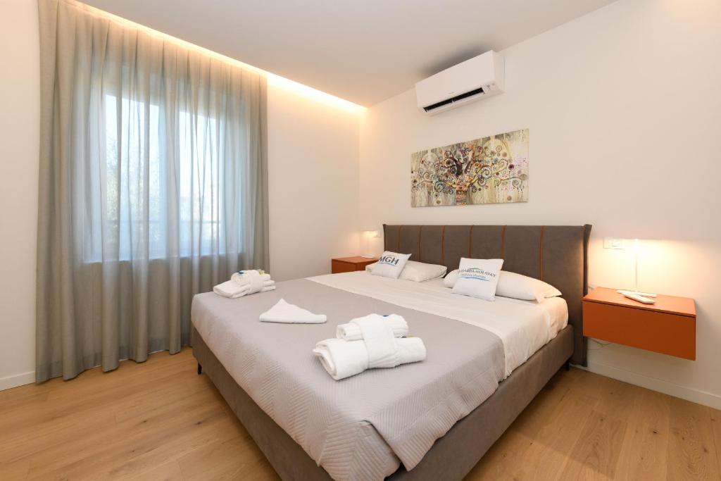 une chambre avec un grand lit avec des serviettes dessus dans l'établissement MGH Luxury - Villa Celeste, à Desenzano del Garda 29 autres photos