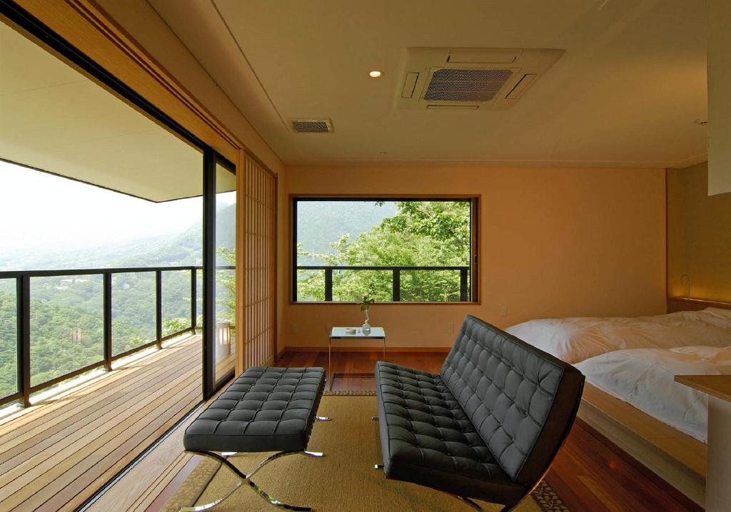 - une chambre avec un lit, une chaise et un balcon dans l'établissement Hakone Tokinoshizuku, à Hakone