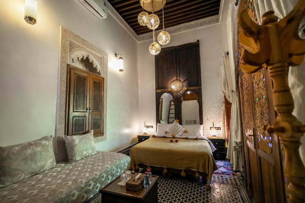 une chambre avec un lit, un canapé et un miroir dans l'établissement Dar Borj, à Fès 37 autres photos