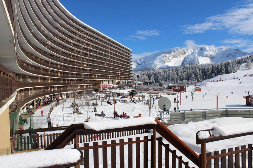 un bâtiment avec une piste de ski dans la neige dans l'établissement Studio chaleureux rénové au pied des pistes, à Saint-Étienne-en-Dévoluy