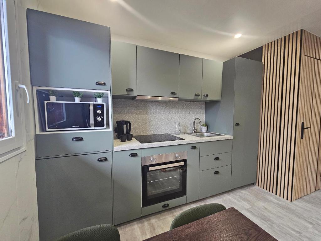 une cuisine avec un réfrigérateur et un micro-ondes dans l'établissement Chalet au pied des pistes, à Saint-François-Longchamp