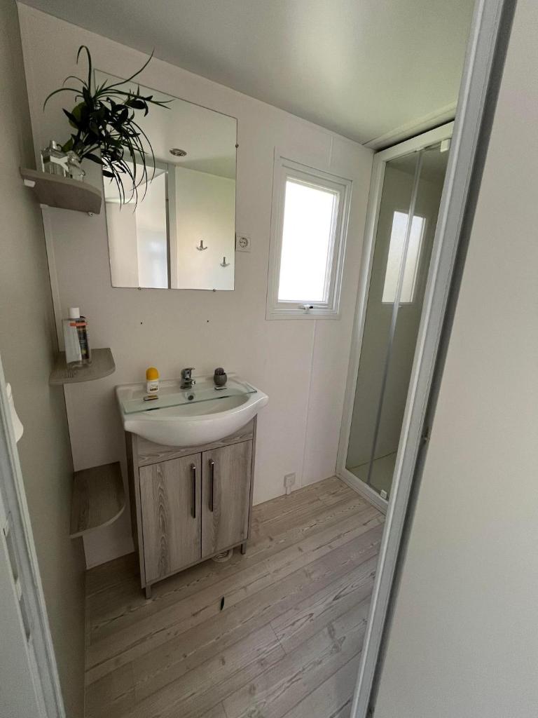 une salle de bain avec un lavabo et un miroir dans l'établissement Mobil Home 2CH Bien Equipé Valras-Plage, à Sérignan